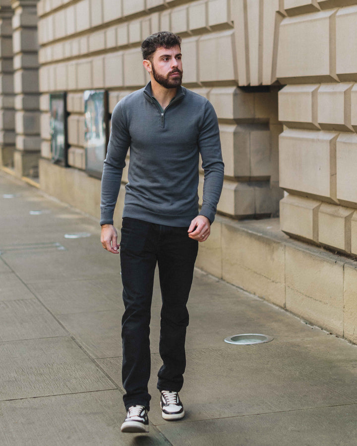 Model wearing our unisex extra-fine merino wool 1/4 zip jumper, made from a lightweight fabric and reactive natural fibre. Ideal for layering under our waterproof dry robes for spectating touchdown sports or walking the dog. The perfect addition to any minimalist capsule wardrobe.