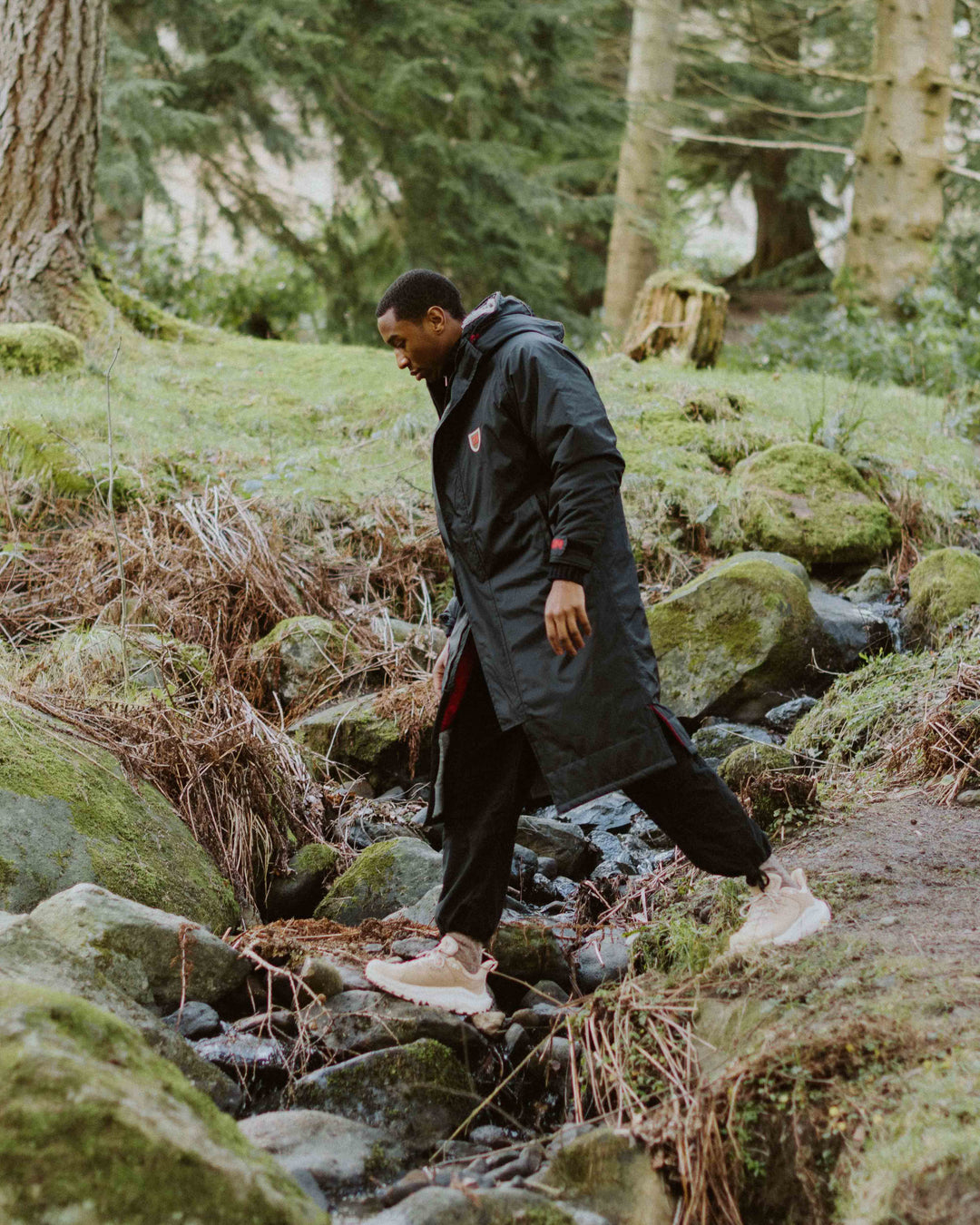 Image of our black dry robe, with recycled polyester inner fleece lining and recycled nylon outer shell. It is waterproof, weatherproof, durable, timeless and functional, making it an essential item to all outdoor wardrobes.