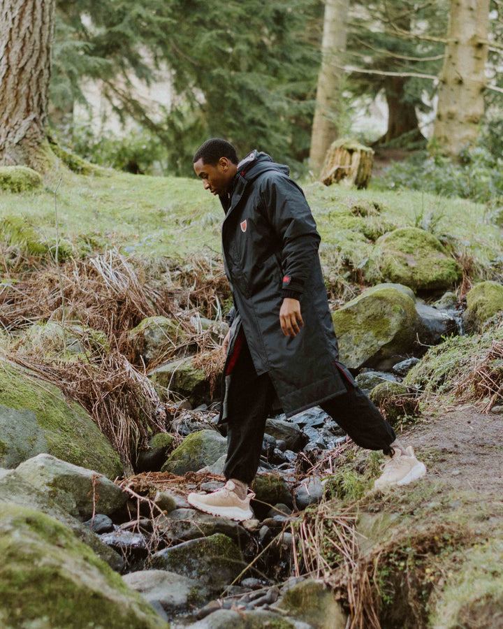 Image of our black dry robe, with recycled polyester inner fleece lining and recycled nylon outer shell. It is waterproof, weatherproof, durable, timeless and functional, making it an essential item to all outdoor wardrobes.